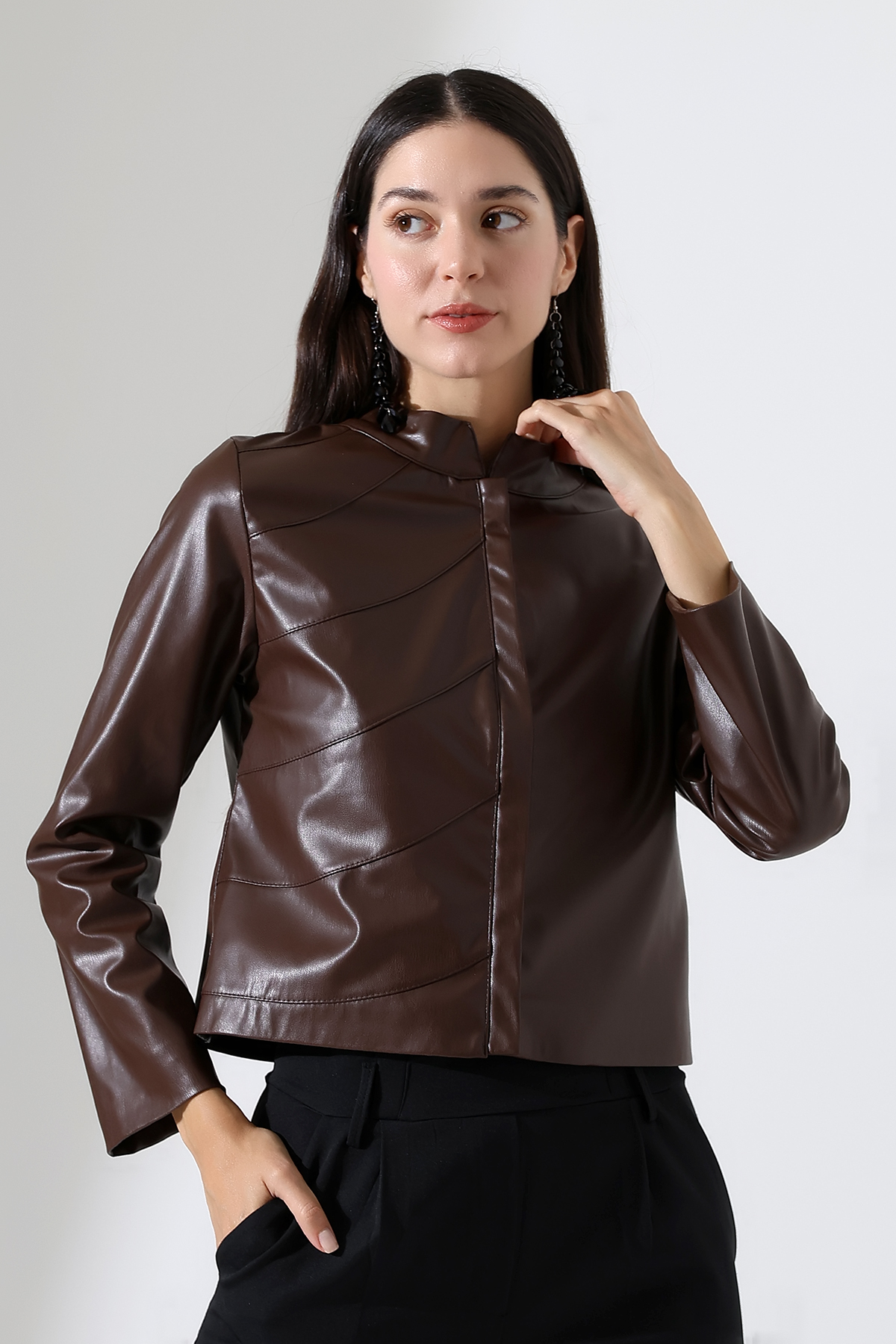 Model wearing a Short jacket  in brown sustainable faux leather  zipped front exquisite design